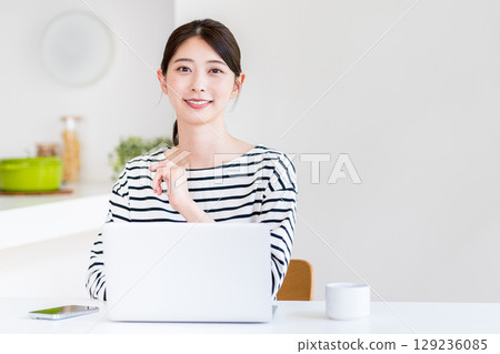 A young woman doing telework in the living room. 129236085