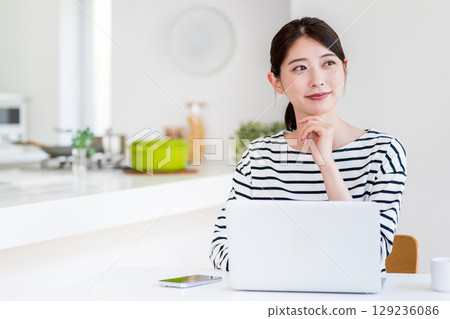 做遠程辦公的一個少婦在客廳。 129236086