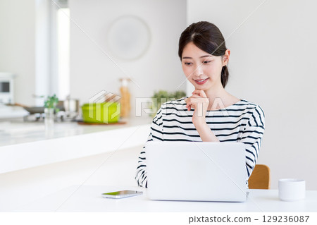 做遠程辦公的一個少婦在客廳。 129236087