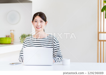 做遠程辦公的一個少婦在客廳。 129236089