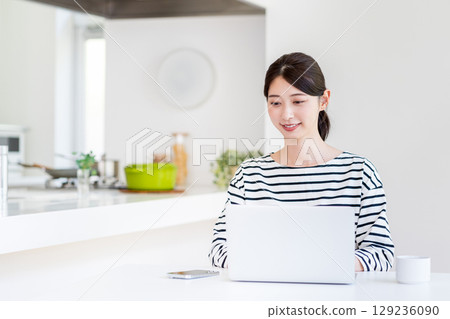 A young woman doing telework in the living room. 129236090