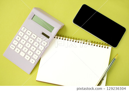 A work desktop with a calculator, calendar, and mobile phone 129236304