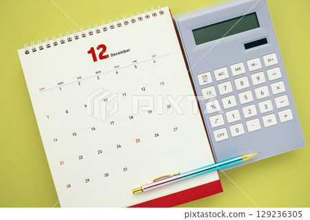 A work desktop with a calculator, calendar, and mobile phone A work desktop with a calculator, calendar, and mobile phone 129236305