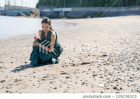 Woman relaxing on the beach Woman relaxing on the beach 129236323