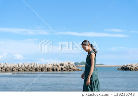 站在藍色大海中的年輕女子 站在藍色大海中的年輕女子 129236748