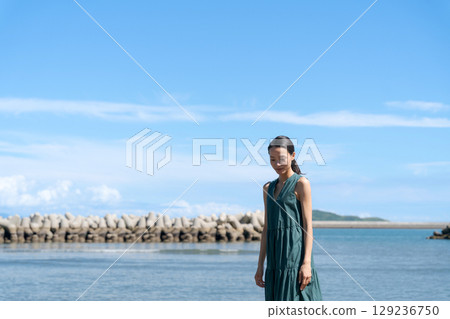 Young woman standing in the blue sea 129236750