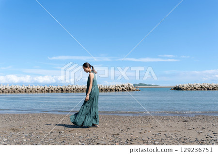 Young woman standing in the blue sea 129236751