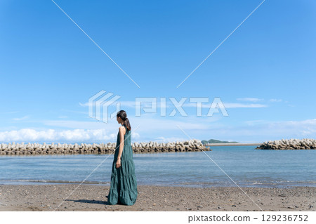 站在藍色大海中的年輕女子 站在藍色大海中的年輕女子 129236752