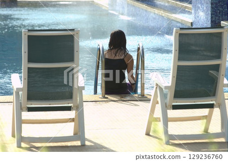 Female in Swimming pool at resort Female in Swimming pool at resort 129236760