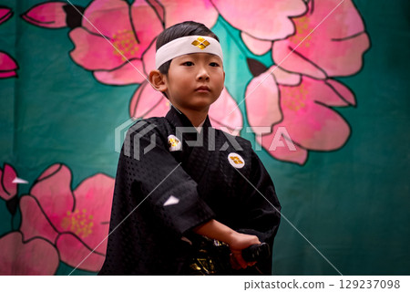 <素材> 一名身著武士服裝的男孩在演奏會上表演武術 129237098