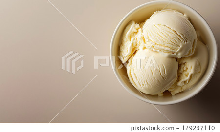Three scoops of vanilla ice cream in white bowl on beige background, creamy dessert served in minimalist composition. 129237110