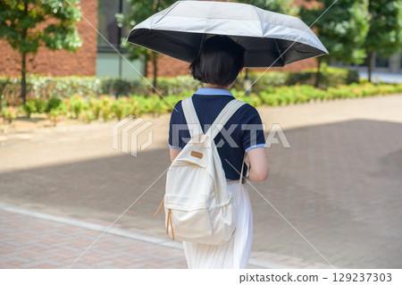 女大學生撐著陽傘走路 129237303