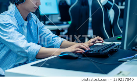 一個男孩全神貫注地用遊戲鍵盤玩電腦遊戲 129237840