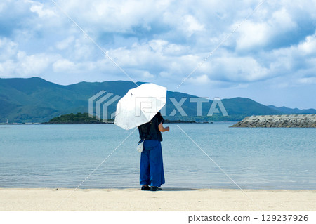 <素材> 夏日海灘上凝視遠方的女子 <素材> 夏日海灘上凝視遠方的女子 129237926