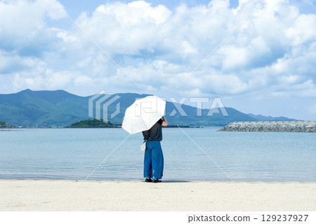 <素材> 夏日海灘上凝視遠方的女子 <素材> 夏日海灘上凝視遠方的女子 129237927