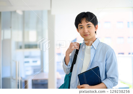 Male student standing in front of a pillar Male student standing in front of a pillar 129238256