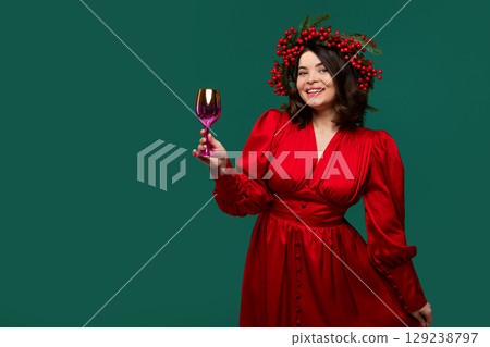 Cheerful woman in red dress holding golden wine glass Cheerful woman in red dress holding golden wine glass 129238797