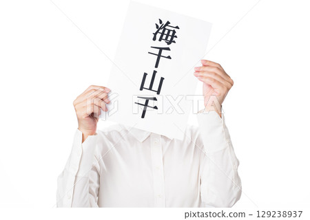 一名身穿白襯衫的人，手裡拿著一張紙，上面寫著「海洋之洋」。 129238937