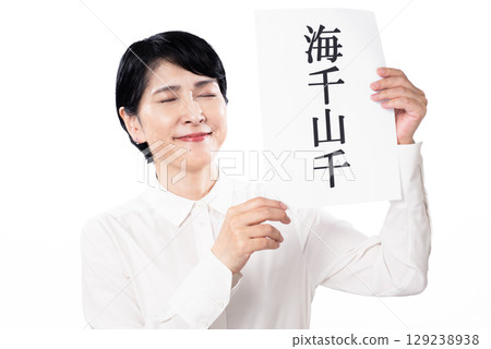 一位笑容滿面的中年婦女拿著一張紙，上面寫著“海洋” 129238938