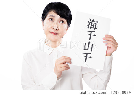 一位中年婦女拿著一張紙，上面寫著“海洋” 129238939