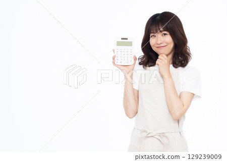 A housewife thinking with a smile while holding a calculator A housewife thinking with a smile while holding a calculator 129239009