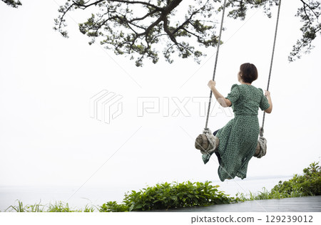 Woman playing on a swing 129239012