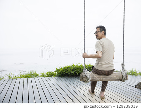 A man riding a swing 129239019
