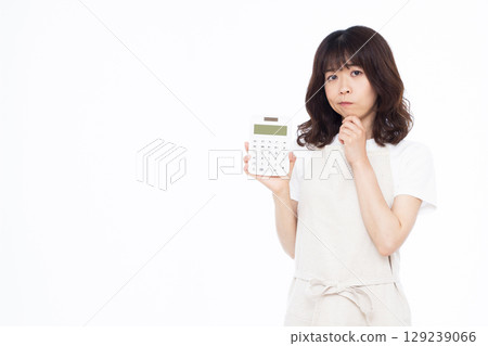A housewife holding a calculator and seriously worrying A housewife holding a calculator and seriously worrying 129239066