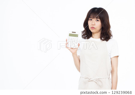 A housewife holding a calculator and seriously worrying 129239068