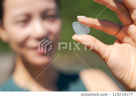 一名婦女在海灘上撿拾海玻璃 129239177