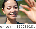 一名婦女在海灘上撿拾海玻璃 129239181