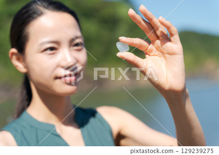 一名婦女在海灘上撿拾海玻璃 129239275