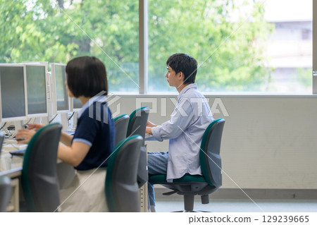 Female student concentrating on PC operation in the ICT room 129239665