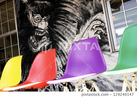 Colorful chairs in a facility with local illustrations painted on the walls 129240147