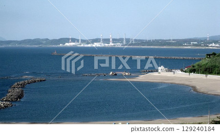 The nuclear power plant seen over the seaside park 129240184