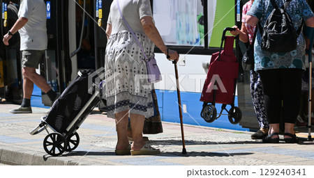 Senior people next to a tram with shopping carts 129240341