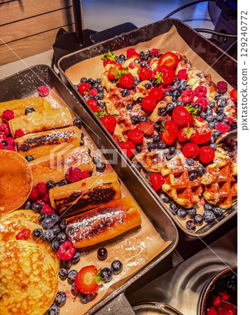 Delicious breakfast buffet with golden pancakes, crispy waffles, and sweet berries. Perfect food concept image for hotel breakfast, brunch menu, or healthy eating visuals. High quality photo 129240772