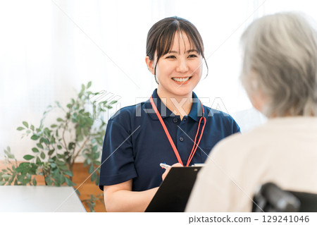 Physical therapist and occupational therapist counseling senior women 129241046