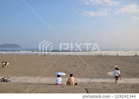 A couple sitting on the steps of Katase Nishihama looking out at the sea A couple sitting on the steps of Katase Nishihama looking out at the sea 129241344
