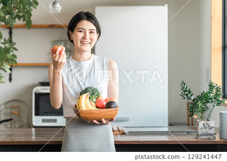 Young Asian woman in sportswear holding vegetables in front of her kitchen (lack of vegetables, nutritional balance, green and yellow vegetables) Young Asian woman in sportswear holding vegetables in front of her kitchen (lack of vegetables, nutritional balance, green and yellow vegetables) 129241447