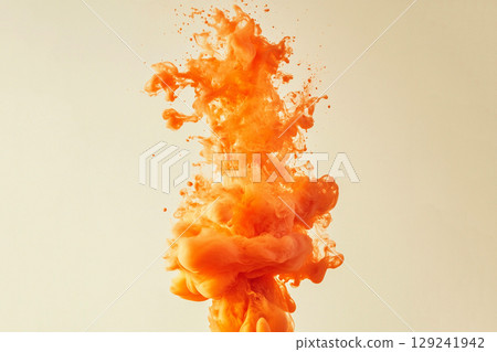 A vibrant orange ink explosion creates a dynamic, captivating texture across the frame 129241942