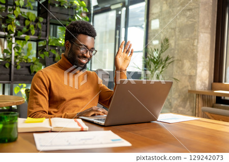 Male freelancer attending video call from contemporary shared office with exposed brick background Male freelancer attending video call from contemporary shared office with exposed brick background 129242073