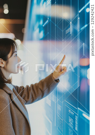 一名女士在市政大樓的資訊面板上獲取信息 129242421