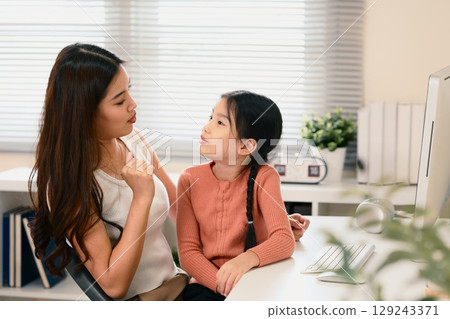 Mother teaching her daughter Chinese language, practicing pronunciation during an online learning Mother teaching her daughter Chinese language, practicing pronunciation during an online learning 129243371