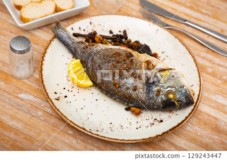 Delicious grilled gilthead bream with lemon 129243447