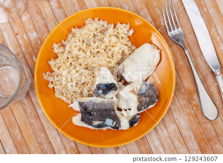 Tender meat of baked cod fillet is garnished with boiled basmati rice. Tender meat of baked cod fillet is garnished with boiled basmati rice. 129243607