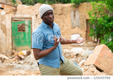 African man behind damaged building 129243769