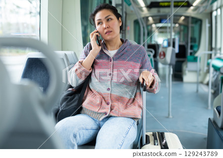Woman using phone inside modern city tram Woman using phone inside modern city tram 129243789