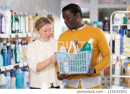Couple man and woman choosing household chemicals in store Couple man and woman choosing household chemicals in store 129243803
