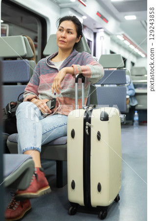 Portrait of asian woman traveler with backpack and suitcase in subway car Portrait of asian woman traveler with backpack and suitcase in subway car 129243858